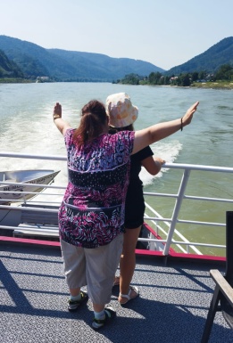 Zwei Menschen stehen auf einem Boot, das fährt