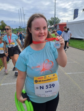 Ein Mädchen beim Frauenlauf mit einer Medaille